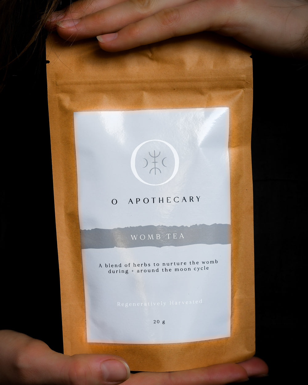 Hands holding a package of loose leaf tea by O Apothecary